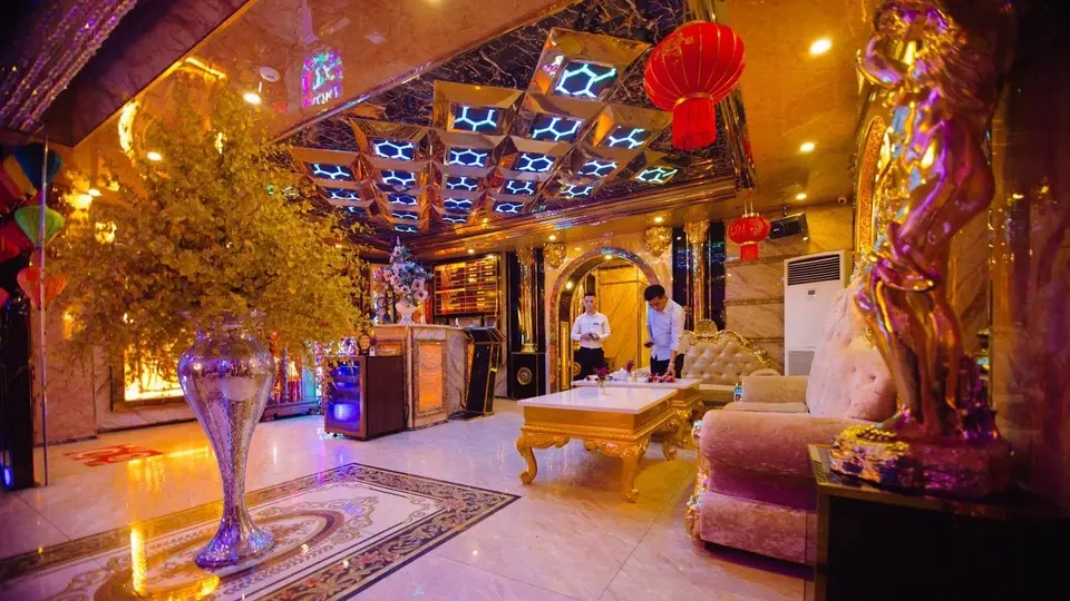 Avatar Karaoke lobby featuring golden hexagonal LED ceiling, marble floors, classic sofas, and gold sculptures