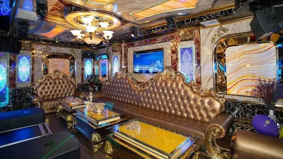 Avatar Karaoke classic room interior with gold-framed mirrors, black marble patterned walls, gold leather sofas, and large screen