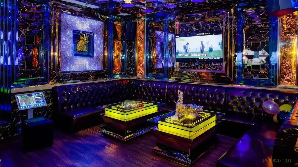 Avatar Karaoke private room 201 with blue lighting, gold-patterned mirror walls, LED table, and leather sofas