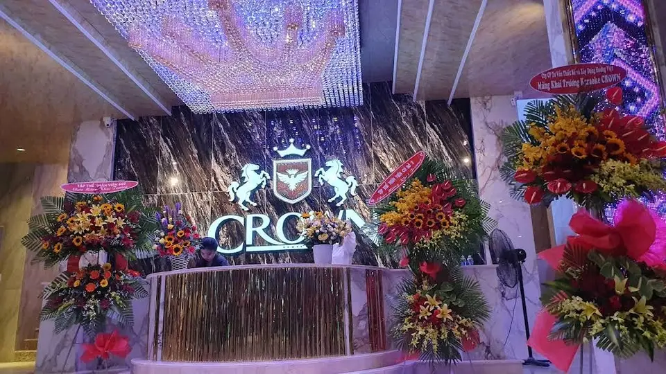 Crown Karaoke entrance featuring a grand crystal chandelier, unicorn emblem, and marble reception desk
