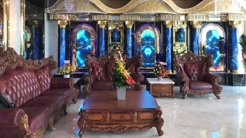 Crown Karaoke lobby lounge with burgundy leather Chesterfield sofas, blue-lit arches, and gold frame accents