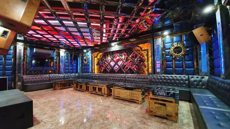 Crown VIP party room with red LED grid ceiling, black leather sofas, and a long row of gold tables