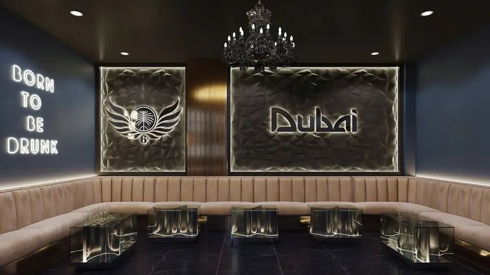 Dubai Karaoke VIP lounge featuring beige padded sofas, a black chandelier, and a 'BORN TO BE DRUNK' neon sign
