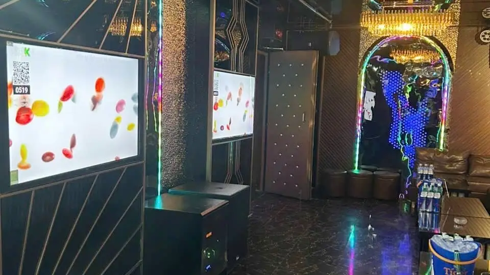 2台の大型カラオケスクリーンとゴールドアーチ型装飾ゲート、カラーLED照明が融合したマスター カラオケルーム内部