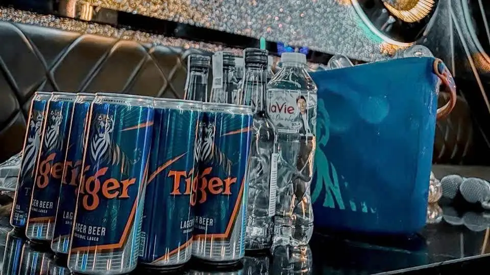 タイガーラガー缶とラヴィミネラルウォーター、アイスバケツがテーブルにセッティングされたマスター カラオケのドリンクサービスの様子
