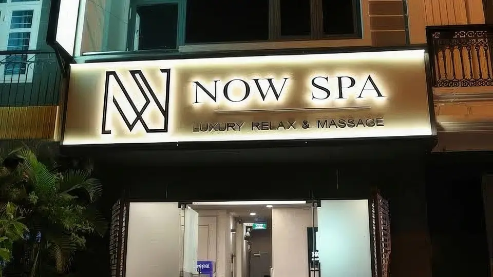 Night view of Now Spa exterior with gold-backlit signage and Luxury Relax & Massage logo