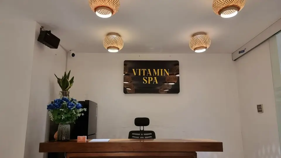 Reception desk and signage at Vitamin Spa with emotional rattan lighting and blue flower decorations